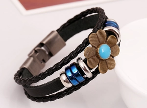 Macro detail of multilayer braided leather bracelet with floral bead and metal buckle