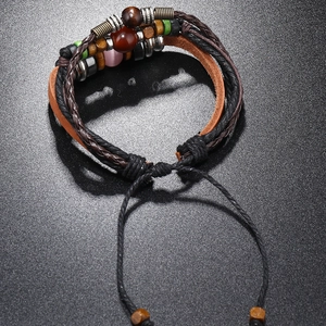 Détail du bracelet multicouche en cuir avec perles en bois et cordon de serrage réglable