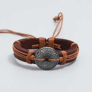 Detail of vintage braided leather bracelet featuring an antique alloy tribal totem charm