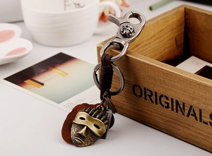 Close-up of vintage bronze alloy skull clasp and braided leather strap keychain