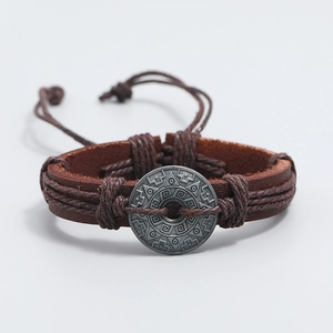 Close-up of handmade brown leather bracelet with tribal zinc alloy charm and slide knot