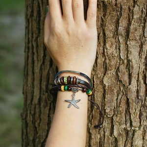 Detail view of handmade multilayer leather bracelet with wooden beads and starfish charm