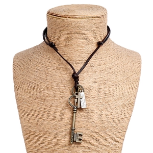 Dettaglio della collana vintage in pelle con chiave in bronzo e ciondolo inciso