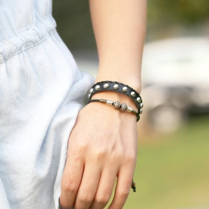 Retro-Set aus schwarzem Lederarmband mit Nieten und Punk-Perlen am Handgelenk