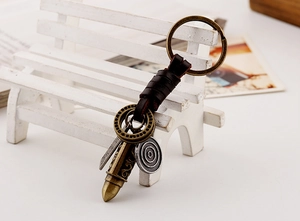 Detail of vintage braided leather keychain with bronze bullet pendant and metal ring