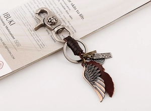 Macro view of vintage leather keychain with wing pendants and skull embossed metal clasp