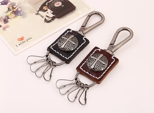 Detail of vintage punk leather cross keychain in black and brown with four key hooks