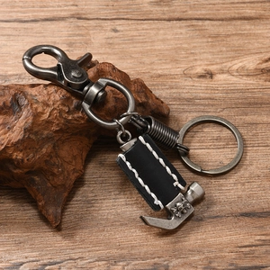 Macro detail of vintage hammer pendant on handmade leather and silver metal keychain