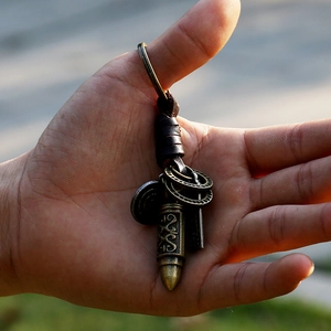 Retro braided leather keychain with bronze bullet pendant and vintage key on a metal ring