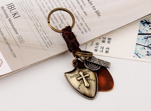 Macro shot of punk braided cowhide keychain with bronze shield and engraved metal tags