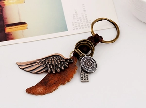 Gros plan porte-clés en cuir vintage avec ailes et gravure Let Your Heart Be Free chic