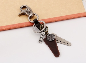 Detail of vintage steampunk leather keychain with skull clasp and saw blade pendants