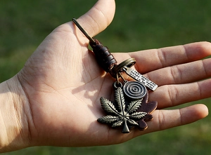 Detailed close-up of bronze maple leaf and engraved metal plates on a leather keychain