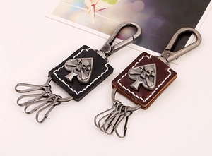 Detail of vintage leather keychains in black and brown with punk skull and spade charms