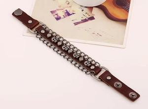 Retro punk bracelet featuring brown leather, skull elements, metal chains and studs