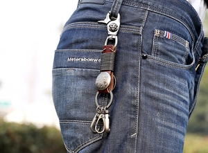 Gros plan du porte-clés en cuir vintage avec boucle d'aigle sur un jean en denim