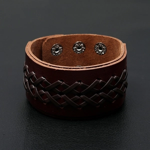 Close-up of vintage wide leather bracelet with braided strips and metal snap buttons