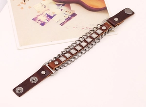 Detailed view of punk brown leather bracelet with silver rivets and metal chains