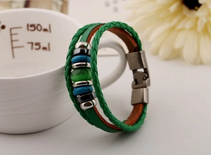 Detailed side view of multi-layer green braided leather bracelet with cat eye stone bead