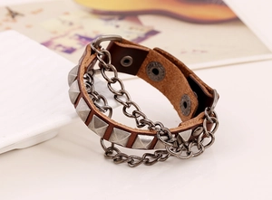 Close-up of punk leather bracelet with silver square studs and layered metal chains