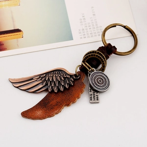 Porte-clés punk vintage en cuir avec ailes en alliage et plaque gravée sur fond blanc pur
