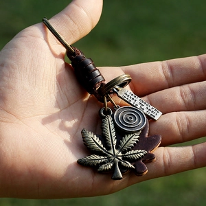 Vintage punk leather keychain featuring bronze maple leaf pendant and woven cowhide cord