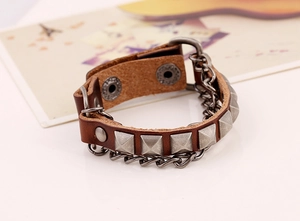 Detail of vintage punk leather bracelet with silver metal studs and side chain hanging