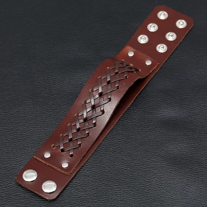 Close-up of brown woven leather wristband with adjustable silver metal snap fasteners