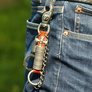 Detail eines Punk-Leder-Schlüsselanhängers mit Totenkopfkreuz an einer Jeans