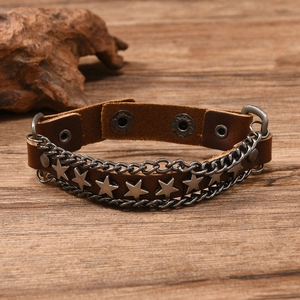 Macro view of vintage punk leather bracelet featuring star studs and double chains detail