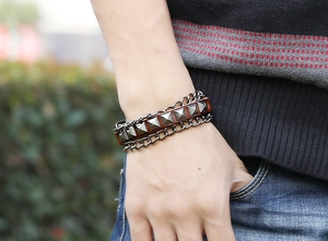 Detail of vintage punk leather bracelet featuring pyramid studs and metal side chains
