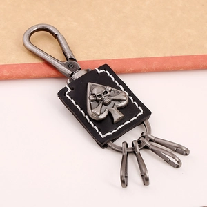 Punk leather keychain featuring silver skull and ace of spades relief on black leather