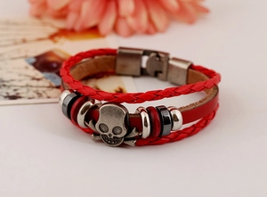 Vue détaillée d'un bracelet punk multicouche en cuir rouge avec crâne et os croisés vintage