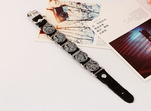 Detail of vintage leather bracelet with embossed silver floral studs and pin buckle