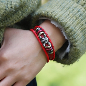 Detail of red punk leather multi-layer bracelet with vintage metal skull charm