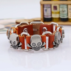 Detail of brown leather punk bracelet with silver skull metal studs and mirror reflection