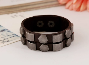 Detail of punk leather bracelet with vintage silver studs and double snap closures