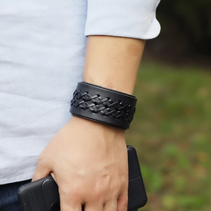 Detailed view of broad black woven leather cuff bracelet featuring punk style textures