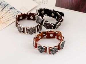 Detail of vintage punk leather bracelets with engraved alloy shields and metal rivets