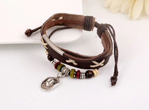 Macro view of vintage leather bracelet featuring beaded charms and cowboy hat pendant