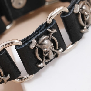 Macro detail of punk leather bracelet featuring vintage silver skulls and metal ring