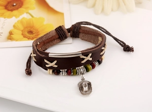 Close-up of vintage multi-layer leather bracelet with silver cowboy hat pendant and beads