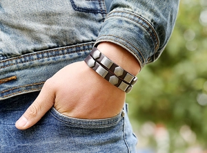 Close-up of double-layer brown leather bracelet with silver geometric metal rivets