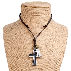 Detail of cross pendant necklace with black and silver charms on brown leather cord