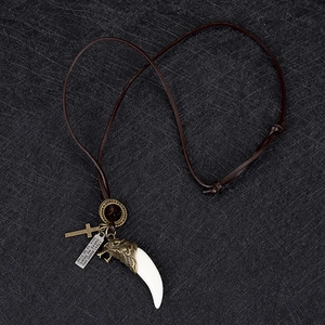 Détail du collier punk en cuir avec fermoir tête de loup, croix et pendentif en défense