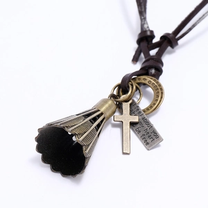 Détail du collier en cuir vintage avec badminton, croix et pendentifs en métal gravé
