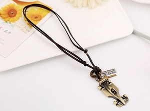 Detailed shot of bronze punk necklace with F1 car pendant on a rustic leather cord