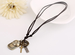 Detail van vintage honkbalpet hanger en kruis aan een donkerbruine leren ketting