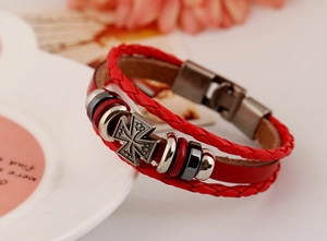 Detailed close-up of a multi-layer red leather punk bracelet with a silver cross pendant