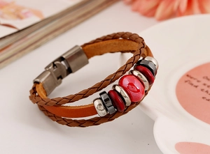 Macro shot of multilayer brown leather bracelet with ceramic beads and metal clasp